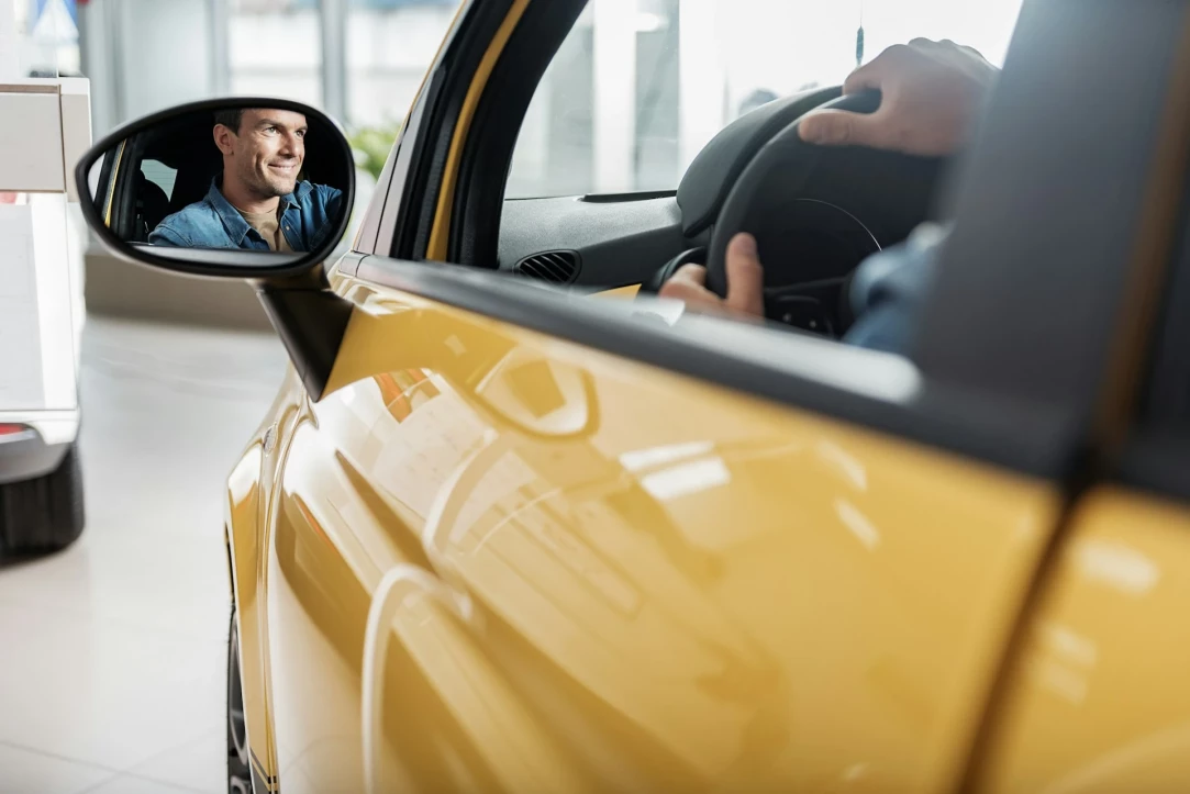 conductor feliz en su coche nuevo
