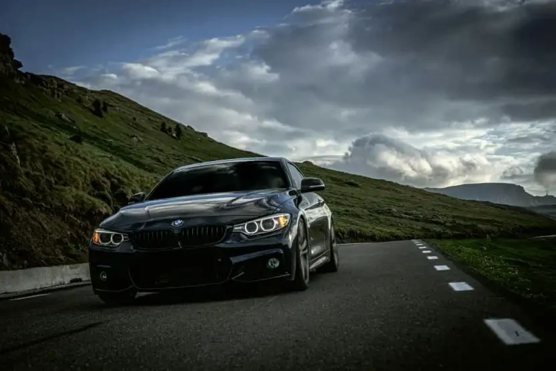 sporty black BMW driving on a mountain road