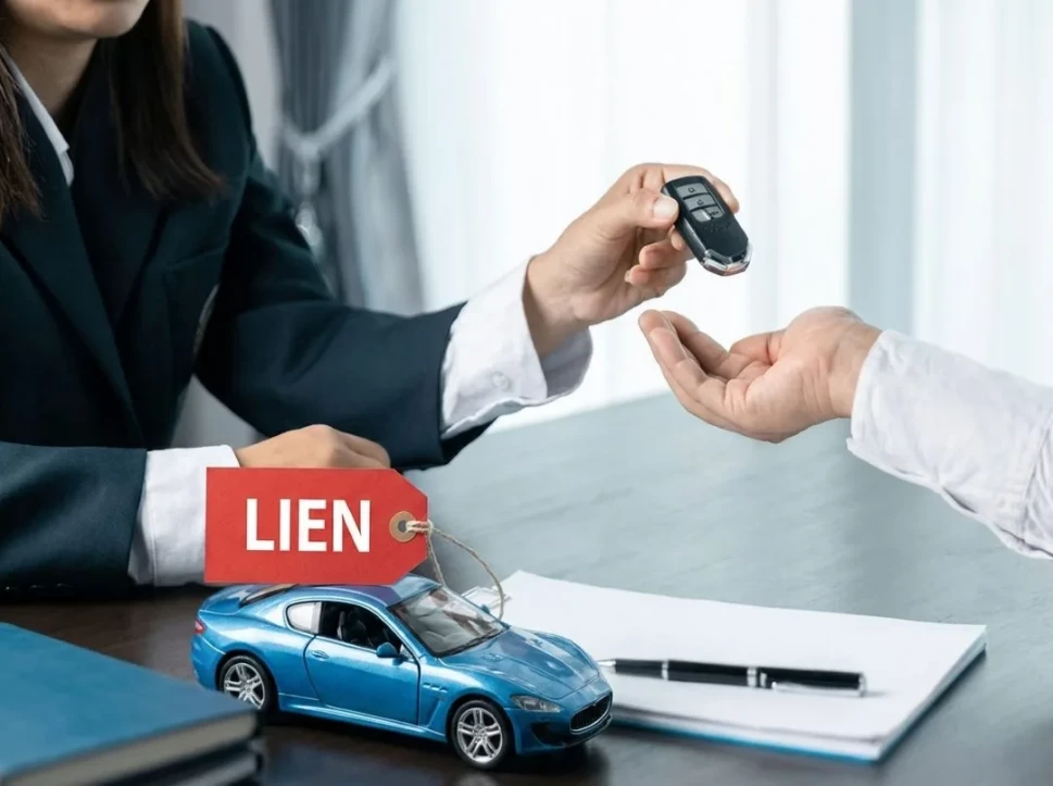 a buyer and seller completing a used car sale while discussing a vehicle lien and title transfer