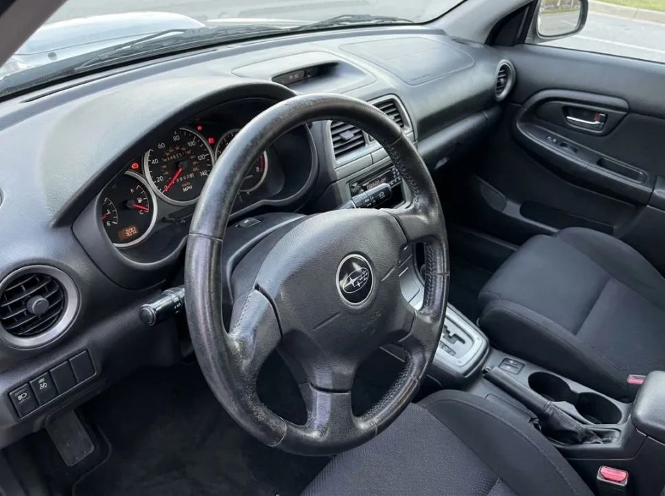 interior of a high-mileage used Subaru with visible steering wheel wear